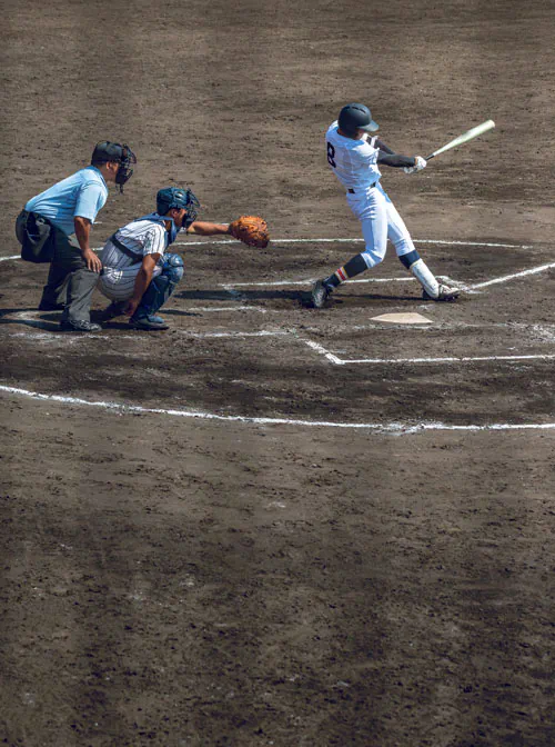 Baseball player swinging bat with catcher and umpire behind him.