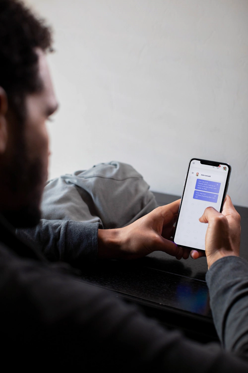 man holding smartphone showing the messages screen from PAC-hub